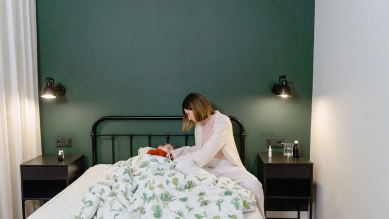 A mother cares for her child with a fever in a warm, cozy bedroom setting.
