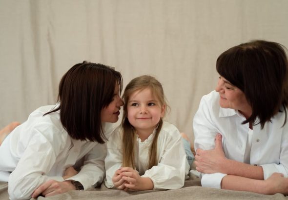 Three generations of women smiling together, symbolizing familial love and connection.