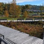 A tranquil autumn park in Bartążek, Poland, with wooden walkways and benches.