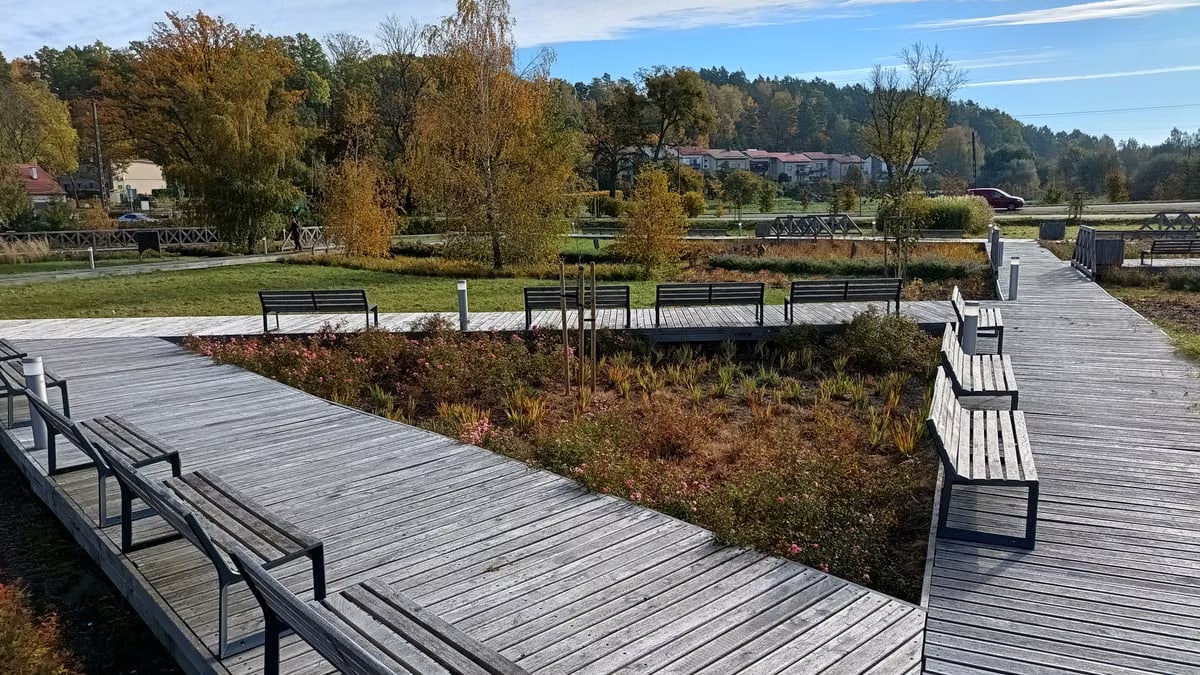 A tranquil autumn park in Bartążek, Poland, with wooden walkways and benches.